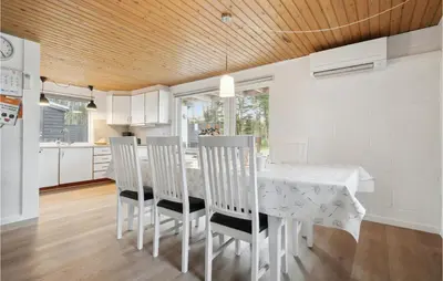 a dining room with a white table and chairs at Cozy Home In Øster Assels With Sauna in Øster Assels