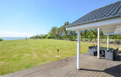 a porch with a table and a field of grass at Pet Friendly Home In Vinderup in Vinderup