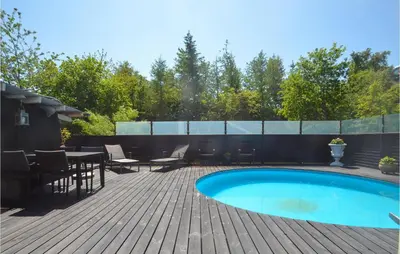 a backyard with a swimming pool and a wooden deck at Gorgeous Home In Fjerritslev in Fjerritslev