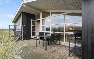 a screened in porch with a table and chairs at Gorgeous Home In Harboøre With Wifi in Harboør