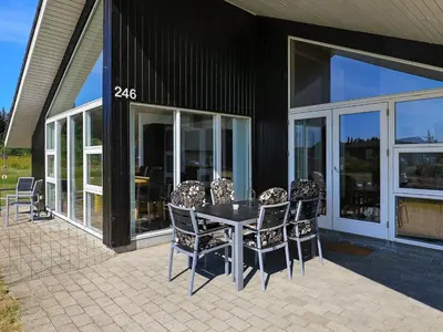a table and chairs on a patio outside of a house at 6 person holiday home in Brovst in Brovst