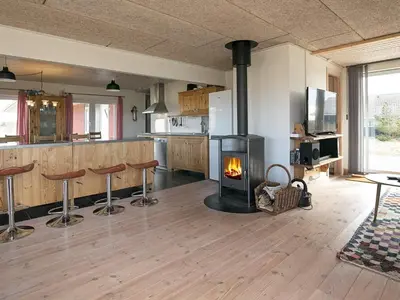 a living room with a wood stove in a kitchen at Luxury Dunes Retreat-By Traum in Pandrup