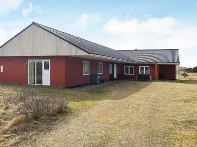 a red house with a field in front of it at Luxury Dunes Retreat-By Traum in Pandrup