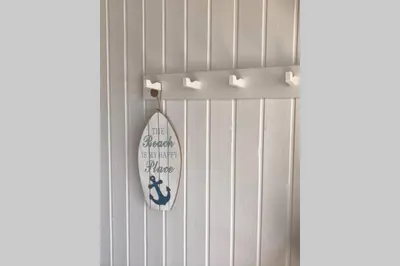 a surfboard on a wall with a sign on it at Seaside VØ in Nørre Vorupør