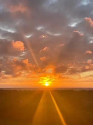 a road with a sunset in the background at Seaside VØ in Nørre Vorupør