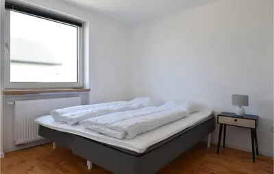 a bed in a white room with a window at Awesome Home In Harboøre With Kitchen in Harboør