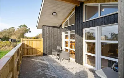 a patio of a house with a table and chairs at Awesome Home In Vestervig With Sauna in Vestervig