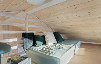 a couch in a room with a wooden wall at Awesome Home In Vestervig With Sauna in Vestervig