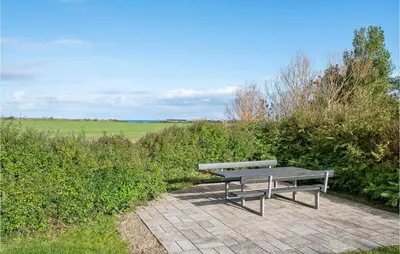 a bench sitting on a brick walkway next to a field at Cozy Home In Vinderup With Wifi in Vinderup