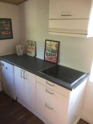 a kitchen with white cabinets and a black counter top at Holiday Home centrum Lemvig in Lemvig