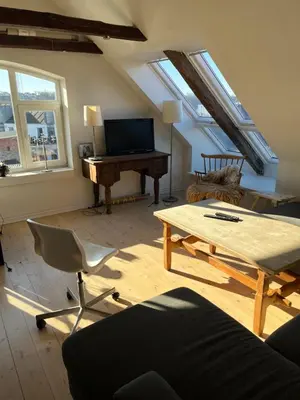 a living room with a piano and a table at Holiday Home Penthouse Lemvig in Lemvig