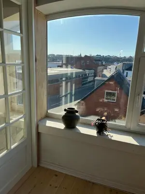a window with two vases sitting on a window sill at Holiday Home Penthouse Lemvig in Lemvig