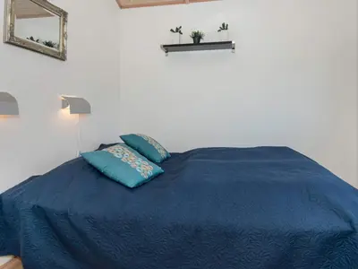 a bedroom with a blue bed with two pillows at Tranquil Retreat in Thorsminde-By Traum in Ulfborg