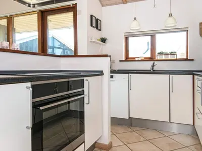 a kitchen with white cabinets and a black oven at Tranquil Retreat in Thorsminde-By Traum in Ulfborg