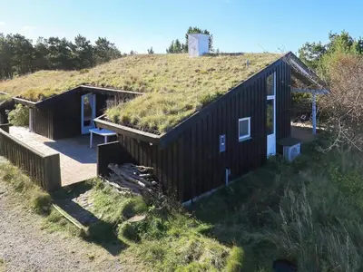 a house with a grassy roof with a bench on the porch at Charming Beach Retreat - By Traum Ferienwohnungen in Fjerritslev