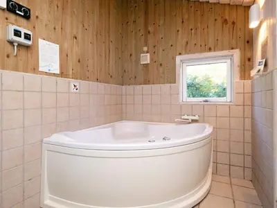 a white tub in a bathroom with a window at Charming Beach Retreat - By Traum Ferienwohnungen in Fjerritslev