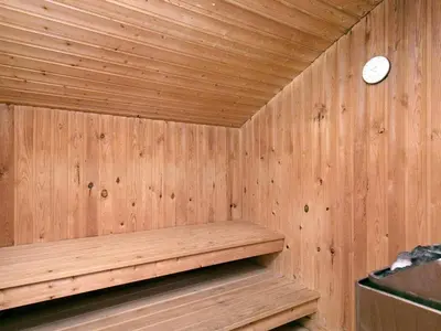 a wooden sauna with a clock on the wall at Charming Beach Retreat - By Traum Ferienwohnungen in Fjerritslev