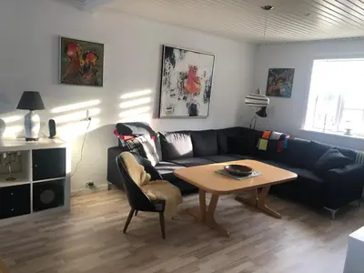 a living room with a couch and a table at BrusaaUdlejning in Nibe