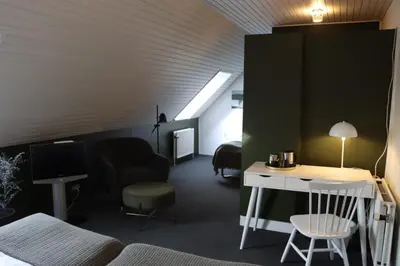 a room with a bed and a desk and a tv at Roslev Hus in Roslev
