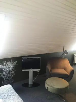 a room with a tv and a chair and a desk at Roslev Hus in Roslev