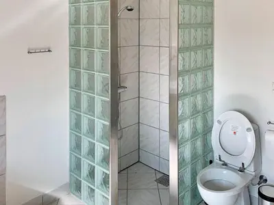 a bathroom with a toilet and a glass shower at Luxury Retreat in Gronhoj-By Traum in Løkken