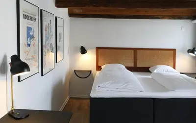 a bedroom with a bed with white sheets and pillows at Hotel Steenbergs in Nykøbing Mors