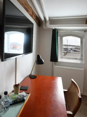 an office with a wooden desk with a television on it at Hotel Steenbergs in Nykøbing Mors
