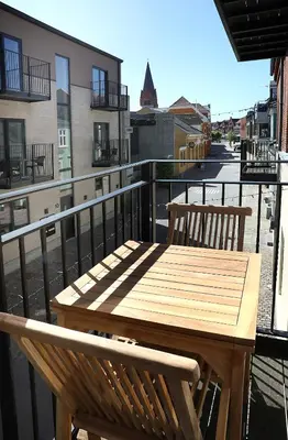 a wooden table and two chairs on a balcony at Hotel Steenbergs in Nykøbing Mors