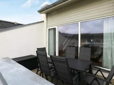 a patio with a table and chairs on a balcony at Cozy Cottage in Skaven Strand-By Traum in Brovst