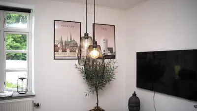 a chandelier hanging in a living room with a tv at Hotelcity in Holstebro