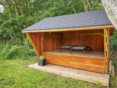 a wooden gazebo with two chairs on it at Cozy Coastal Cottage Retreat-By Traum in Sindrup