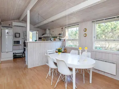 a kitchen and dining room with a white table and chairs at Bright Coastal Retreat in Vorupor-By Traum in Thisted