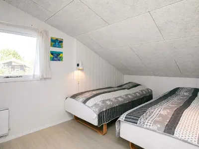 two beds in a white room with a window at 8 person holiday home in Blokhus in Blokhus