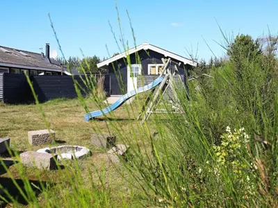 a slide in a yard in front of a house at 8 person holiday home in Blokhus in Blokhus