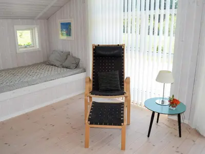 a room with a bed and a chair and a table at 6 person holiday home in Løkken in Løkken
