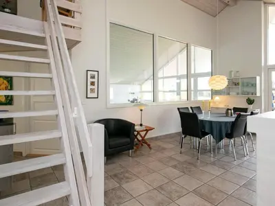 a dining room and living room with a spiral staircase at 8 person holiday home in Skals in Skals