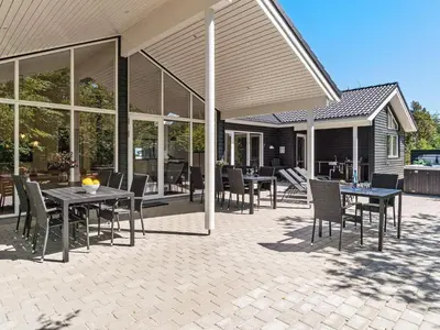 a patio with tables and chairs and windows at 18 person holiday home in Fjerritslev in Fjerritslev