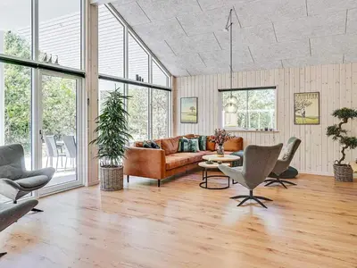 a living room with a couch and a table and chairs at 18 person holiday home in Fjerritslev in Fjerritslev