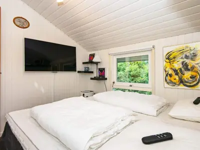 two beds in a room with a clock on the wall at 6 person holiday home in Brovst in Brovst