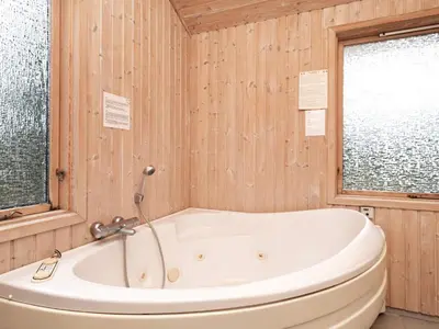 a bath tub in a bathroom with wooden walls at 6 person holiday home in Fjerritslev in Fjerritslev