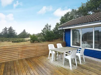 a wooden deck with a table and chairs on it at 6 person holiday home in Fjerritslev in Fjerritslev