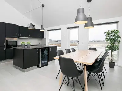 a kitchen with a wooden table and black cabinets at 6 person holiday home in Løkken in Løkken