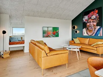 a living room with two couches and a painting of an older woman at 10 person holiday home in Løkken in Løkken