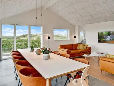 a living room with a table and a couch at 10 person holiday home in Løkken in Løkken