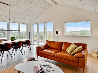 a living room with a couch and a table at 10 person holiday home in Løkken in Løkken