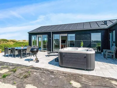 a house with a hot tub on a patio at 10 person holiday home in Løkken in Løkken