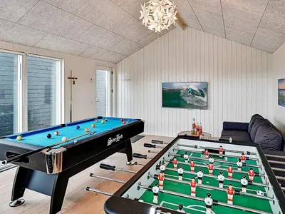 a living room with a pool table and a couch at 10 person holiday home in Løkken in Løkken