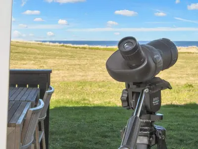 a camera on a tripod next to a bench at Family Holiday Home by North Sea in Lemvig
