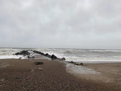 a beach with rocks on the sand and the ocean at Family Holiday Home by North Sea in Lemvig