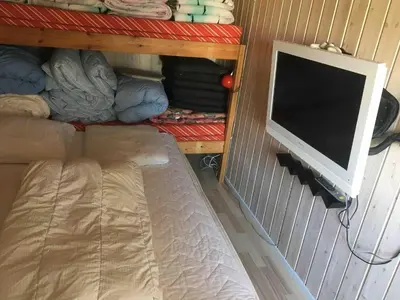 a computer monitor sitting on a wall next to a bed at Beautiful and amazing view - 3 bedroom cottage in Vinderup